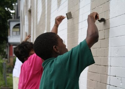 At a NeighborWorks Week event, volunteers help NHS of New Haven paint a mural